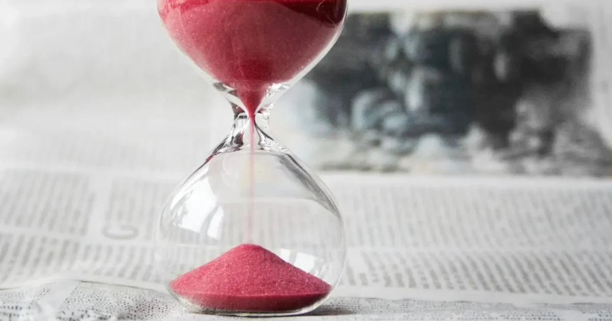 Pourquoi la patience est-elle si importante dans le trading ? Illustration conceptuelle montrant un trader patient assis devant un graphique en chandeliers, attendant calmement le signal d'entrée parfait. Une horloge symbolise le temps qui passe, tandis qu'une flèche verte ascendante représente le gain obtenu grâce à l'attente stratégique, contrastant avec un trader impatient qui subit des pertes.